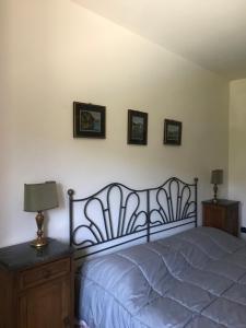 sypialnia z łóżkiem i 3 zdjęciami na ścianie w obiekcie Appartamenti Il Capomandro w mieście SantʼAnatolia