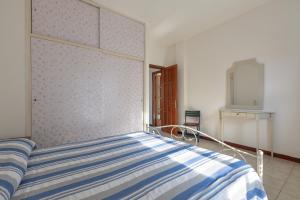 um quarto com uma cama com um cobertor listrado azul e branco em A casa di Vito by BarbarHouse em Torre Pali