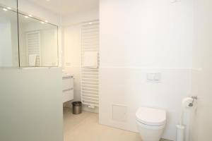 une salle de bain blanche avec toilettes et lavabo dans l'établissement Haus Metropol - App. 234 SWB, à Westerland 14 autres photos