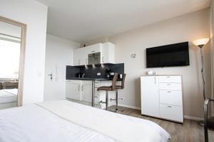- une chambre avec un lit et un bureau avec une télévision dans l'établissement App. Preetz 32 OB, à Westerland