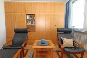 a living room with two chairs and a table at App. Kleinhubbert in Westerland