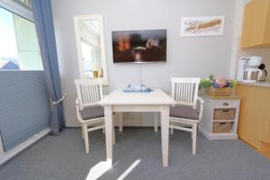 eine Küche mit einem weißen Tisch und 2 Stühlen in der Unterkunft Grimme 15 WB in Westerland