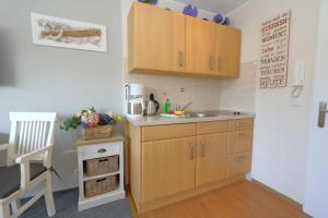 eine kleine Küche mit Holzschränken und einem Waschbecken in der Unterkunft Grimme 15 WB in Westerland
