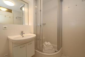 a bathroom with a shower and a sink and a sink at Haus am Meer14 - App. 144 WB in Westerland