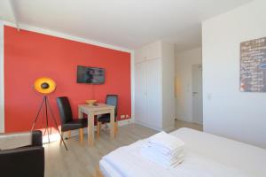 um quarto com uma mesa e uma parede vermelha em Dorow 48 WB em Westerland