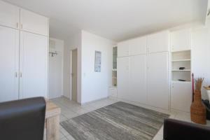 uma sala de estar com armários brancos e um tapete em Dorow 48 WB em Westerland
