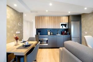 eine Küche und ein Wohnzimmer mit einem Tisch und einer Couch in der Unterkunft Apartamento Calle Larga 46 in Jerez de la Frontera