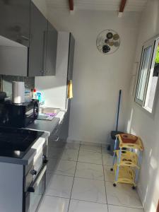 eine Küche mit einer Spüle und einer Arbeitsplatte in der Unterkunft Bungalow vacances in Sainte-Rose