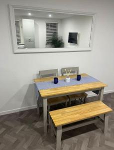 a table and bench in a room with a mirror at 4 Mellors Court in Warwick