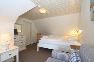 - une chambre blanche avec un lit et un bureau dans l'établissement Friesenhaus App. I, à Westerland