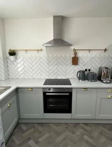 a kitchen with white cabinets and a stove top oven at 4 Mellors Court in Warwick