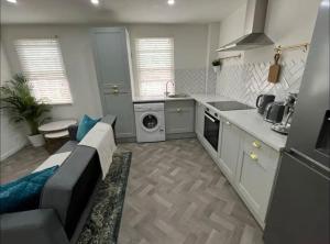 a kitchen with a couch and a kitchen with a stove at 4 Mellors Court in Warwick