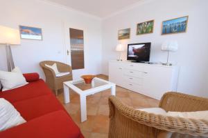 a living room with a red couch and a tv at App. Hackmack 62 in Westerland +4 photos