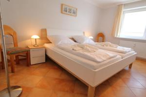 a large white bed in a room with a window at App. Hackmack 62 in Westerland