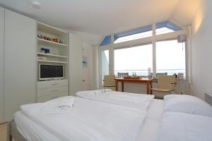 ein Schlafzimmer mit zwei Betten und einem Tisch und einem Fenster in der Unterkunft Haus am Meer14 - App. 159 in Westerland