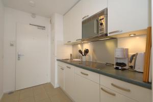 a kitchen with white cabinets and a counter top at Haus am Meer14 - App. 159 in Westerland