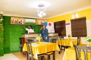 two people standing at the counter of a restaurant at Suru Express Hotel in Suru Lere