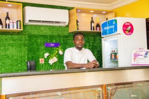 a man standing behind a counter in a restaurant at Suru Express Hotel in Suru Lere