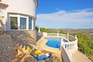 a balcony with chairs and a swimming pool on a house at Villa Lehman - PlusHolidays in Calpe