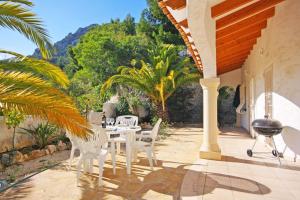 a patio with a table and chairs and trees at Villa Lehman - PlusHolidays in Calpe