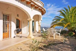 a patio with chairs and a grill on a house at Villa Lehman - PlusHolidays in Calpe