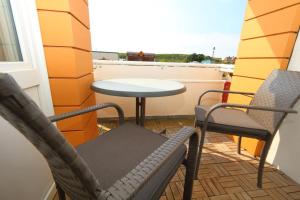 a patio with two chairs and a table on a balcony at App König 01 in Westerland (Sylt)