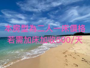 una playa con escritura rosa en la arena y el océano en Travel Time Homestay, en Huxi