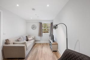 ein Wohnzimmer mit einem Sofa und einem TV in der Unterkunft Cavendish 37 in Tideswell