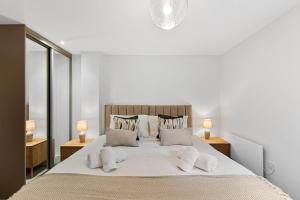 ein weißes Schlafzimmer mit einem großen Bett mit Kissen in der Unterkunft Cavendish 37 in Tideswell