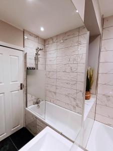 a white bathroom with a tub and a shower at The Tansley Gardens in Darlington