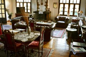 a living room with couches and a table and chairs at Archontariki Guesthouse in Polygryos