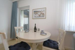 a white dining room with a white table and chairs at Fischer Boysenstraße in Westerland +9 photos