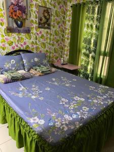a bed with a blue comforter with flowers on it at 1-BR Condo Unit Urban Deca Homes Manila in Manila