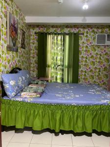 a bedroom with a bed with blue sheets and flowers at 1-BR Condo Unit Urban Deca Homes Manila in Manila