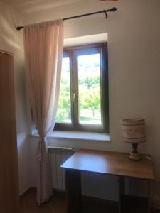ein Fenster in einem Zimmer mit einem Holztisch und einem sidx sidx sidx in der Unterkunft Appartamenti Il Capomandro in SantʼAnatolia