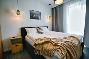 ザジェチェにあるApartamenty Laguna Beskidów - A33のベッドルーム1室(毛布付きのベッド1台付)