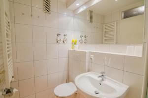 biała łazienka z umywalką i toaletą w obiekcie Haus Sylter Welle 5-49 OB w mieście Westerland