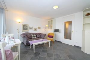 uma sala de estar com um sofá e uma mesa em Haus Sylter Welle 6-60 OB em Westerland