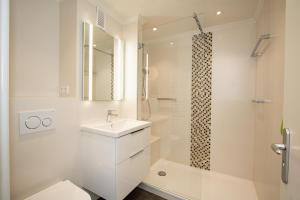 a white bathroom with a sink and a shower at Haus Metropol 335 OB in Westerland (Sylt) +10 photos