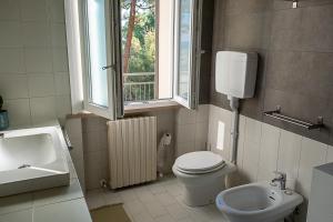 a bathroom with a toilet and a sink and a window at Bea&Berto - B&B - in Trebbiantico +83 photos