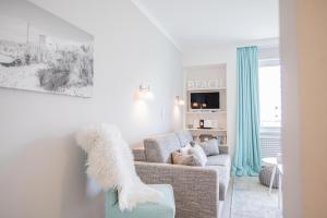 a white living room with a couch and a window at App. Theo 50 in Westerland