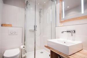 a white bathroom with a sink and a shower at App. Theo 50 in Westerland +16 photos