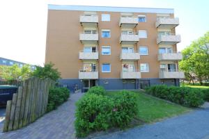 a tall building with balconies and bushes in front of it at App. Theo 50 in Westerland