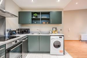 a kitchen with a washing machine and a sink at Central Belfast Apartments, Victoria Place in Belfast
