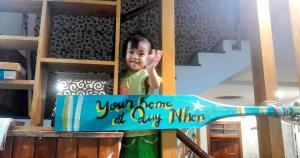a young child is standing next to a toothbrush at Sông Suối Homestay in Quy Nhon