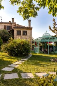 einen Garten mit einem Haus und einem Pavillon in der Unterkunft Agriturismo Corte Decia in Saludecio