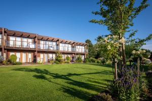 an exterior view of a building with a lawn at Domki Apartamentowe Bueno in Dąbki