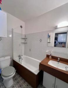 a bathroom with a toilet and a tub and a sink at Avec balcon, au pied des pistes et randos in Villard-de-Lans
