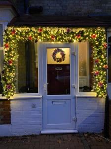 a front door with christmas lights and a wreath at Three Bedroom Family home with garden in Walthamstow in London