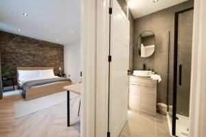 sypialnia z łóżkiem, umywalką i lustrem w obiekcie The Battersea Scenery - Elegant 2BDR Flat w Londynie